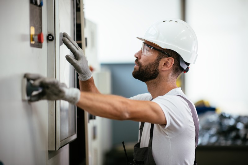 Techniker mit Helm und Schutzhandschuhen bei der Arbeit